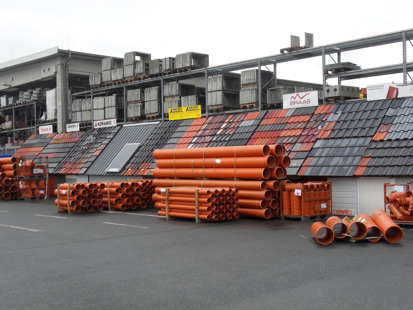 Склад с оранжевыми трубами, черепицей и бетонными блоками